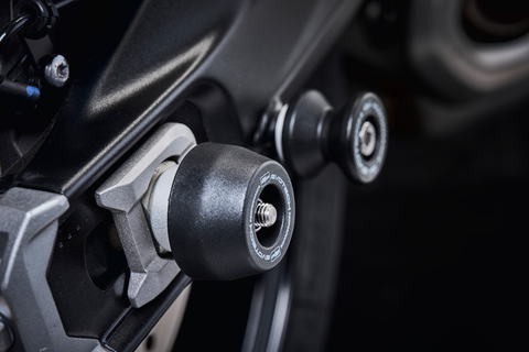 The rear wheel of the Tiger Sport 660 Trident with the EP Spindle Bobbins Kit’s nylon bobbin fitted, protecting the swingarm and fitted near EP Paddock Stand Bobbins.